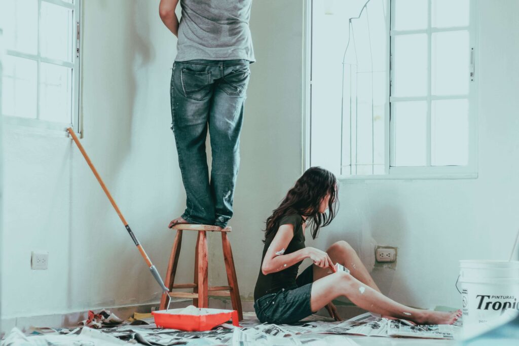 young couple painting new house