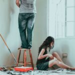 young couple painting new house